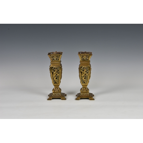 103 - A pair of Aesthetic Movement reticulated brass vases of tapering square form, decorated with putto, ... 