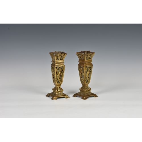 103 - A pair of Aesthetic Movement reticulated brass vases of tapering square form, decorated with putto, ... 