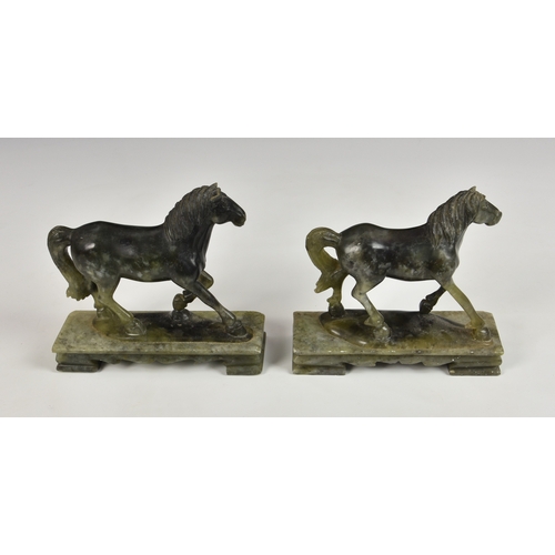 123 - A near pair of carved green soapstone horses 20th century, raised on rectangular plinths, 6½in. (16.... 