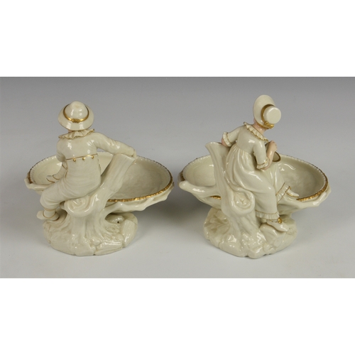 124 - A pair of Royal Worcester figural sweetmeat dishes modelled by James Hadley, after Kate Greenaway, i... 