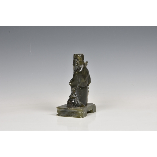 146 - An Oriental green hardstone figure of a deity / scholar sitting upon a raised platform, 7 3/8in. (18... 