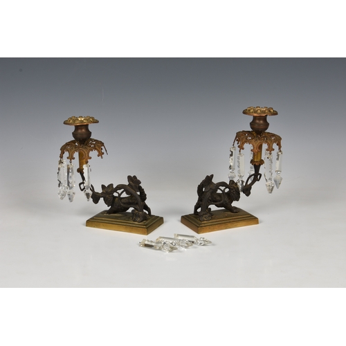 179 - A pair of 19th century patinated and gilt bronze lustre candlesticks the urn nozzles over pierced co... 