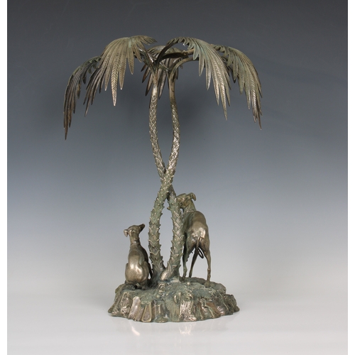 196 - A silver plated centrepiece in the form of two greyhounds sheltering beneath palm trees in the manne... 