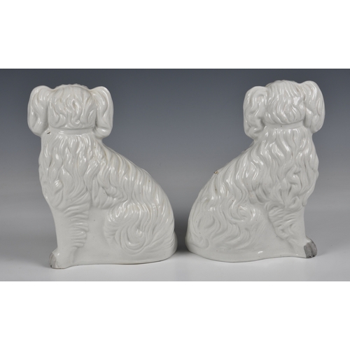 204 - A pair of Staffordshire King Charles spaniels in white glaze with gilt highlights, 9 ½ in. (24.1cm.)... 