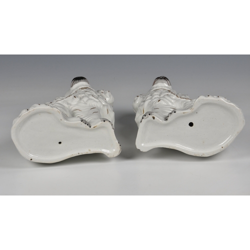 204 - A pair of Staffordshire King Charles spaniels in white glaze with gilt highlights, 9 ½ in. (24.1cm.)... 