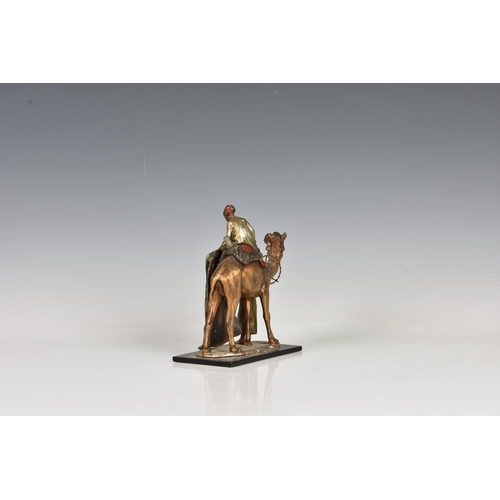 241 - An Austrian Bergman style cold painted spelter table lighter in the form of a camel and two Arabian ... 