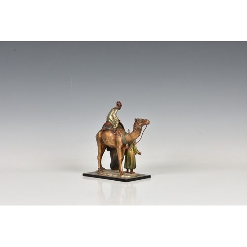 241 - An Austrian Bergman style cold painted spelter table lighter in the form of a camel and two Arabian ... 