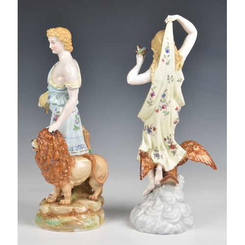 284 - A pair of Rudolstadt porcelain figures in floral dress of Heracles standing with a lion and Hebe kne... 