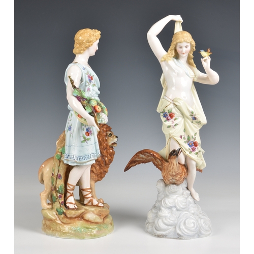 284 - A pair of Rudolstadt porcelain figures in floral dress of Heracles standing with a lion and Hebe kne... 