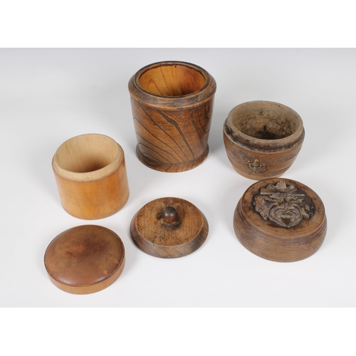 49 - Three treen containers to include a barrel shaped version with applied metal green man mask to cover... 