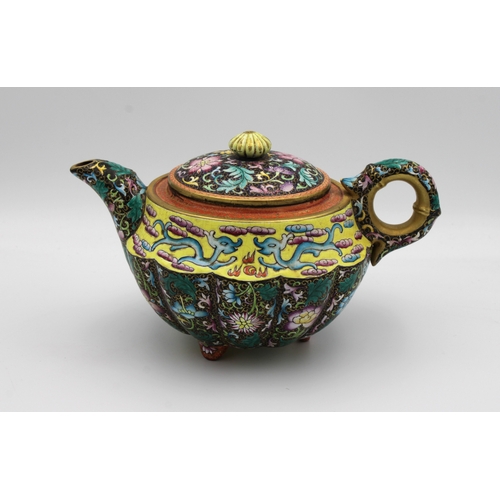 540 - A Chinese Yixing lobed teapot and cover painted in polychrome enamels depicting chrysanthemums and p... 