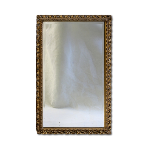 634 - A modern rectangular gilt pierced framed mirror with bevelled glass plate, 67 x 42cm.