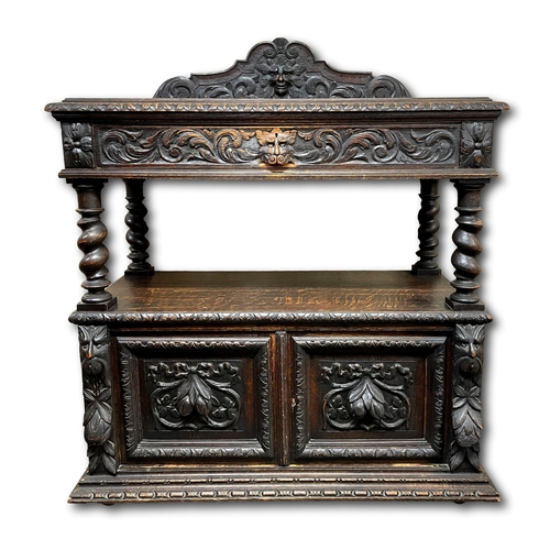 641 - A Victorian carved oak buffet the gallery with carved foliate scroll and mask, over a foliate moulde... 