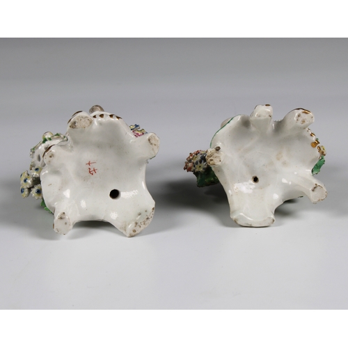 8 - A pair of Chelsea-Bow porcelain bocage figures, late 18th century each carrying baskets of fruit and... 