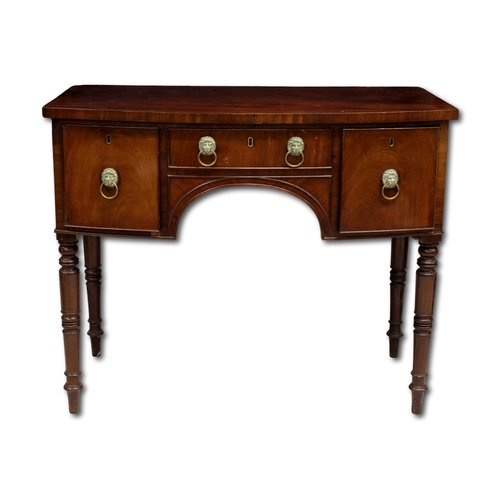 654 - A Regency mahogany bow fronted sideboard Moulded top above three cockbeaded drawers and four turned ... 