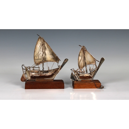 33 - Two Middle Eastern white metal models of Dhows, on wooden bases, unmarked, 15.5cm. and 11.4cm. long,... 