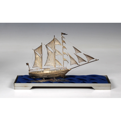 34 - A 900 filigree silver sailing ship, 20.5cm. long, in glass display, overall 26.5cm.