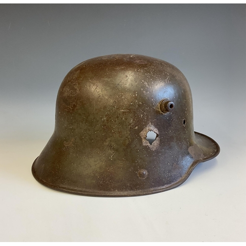 138 - A German WWI steel Stahlhelm helmet, reportedly a Somme relic, the helmet with bullet hole to side. ... 