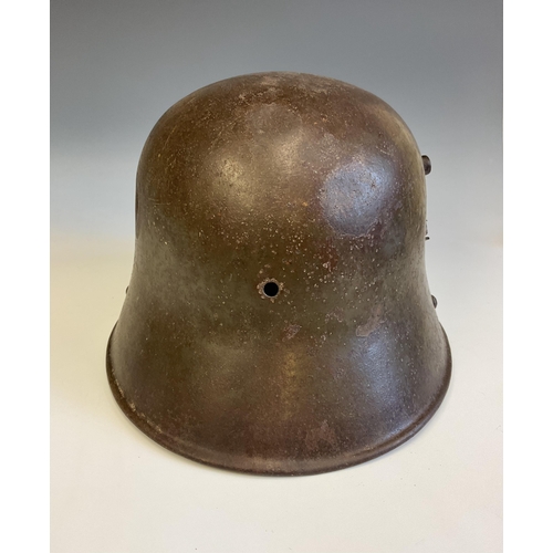 138 - A German WWI steel Stahlhelm helmet, reportedly a Somme relic, the helmet with bullet hole to side. ... 