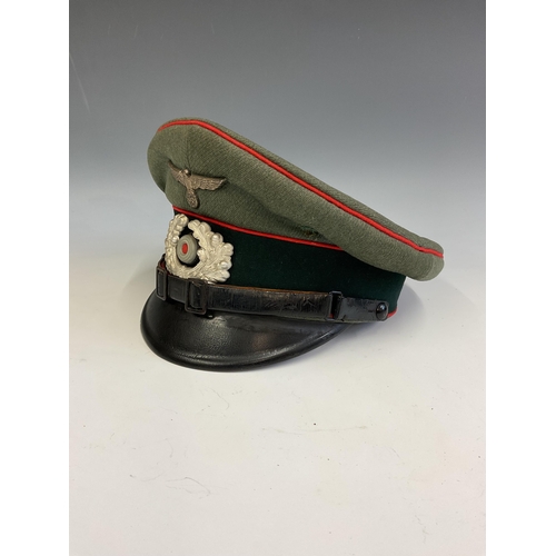 163 - A German Army World War Two Artillery Peaked Cap, red piping to the crown and bordering the central ... 