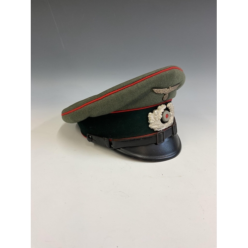 163 - A German Army World War Two Artillery Peaked Cap, red piping to the crown and bordering the central ... 