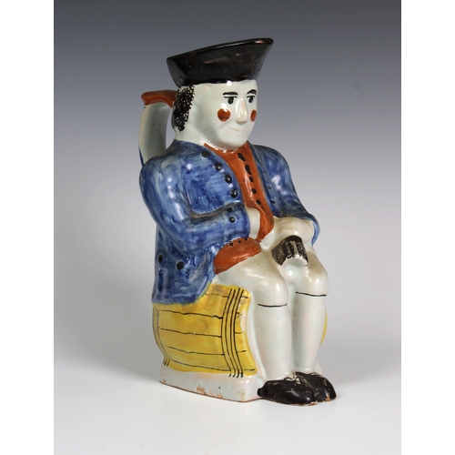 103 - An early 19th century Staffordshire pearlware Toby Jug of a gentleman, in 18th century dress seated ... 