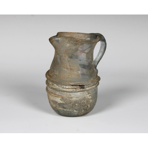 112 - An ancient Roman glass jug, possibly 3rd - 4th century CE, featuring a single loop handle and traile... 