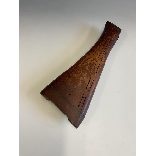 21 - An original gun stock made into a cribbage board, raised on three bullet supports, 29.2 cm.