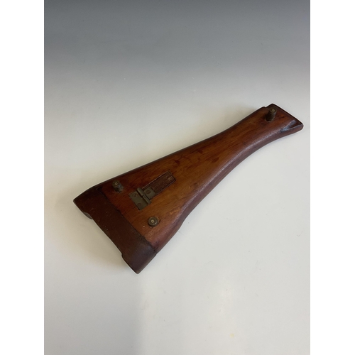 21 - An original gun stock made into a cribbage board, raised on three bullet supports, 29.2 cm.