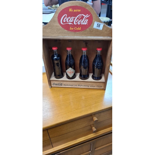 58 - Set of 4 Historic Coca Cola Bottles in a Wooden Display Cabinet. released c.2012