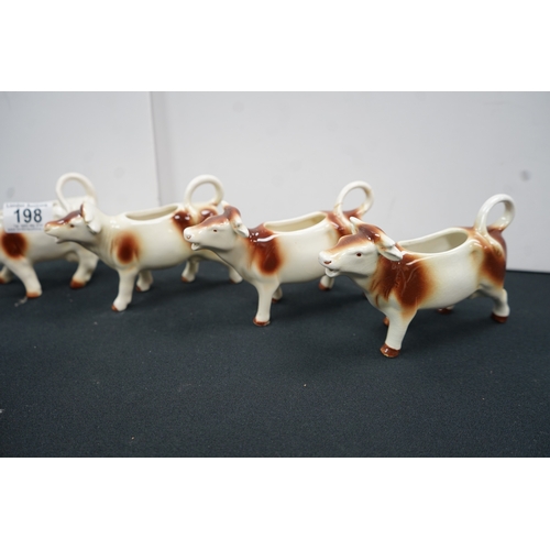 1198 - Four west German cow milkers and one novelty kangaroo salt and pepper shaker