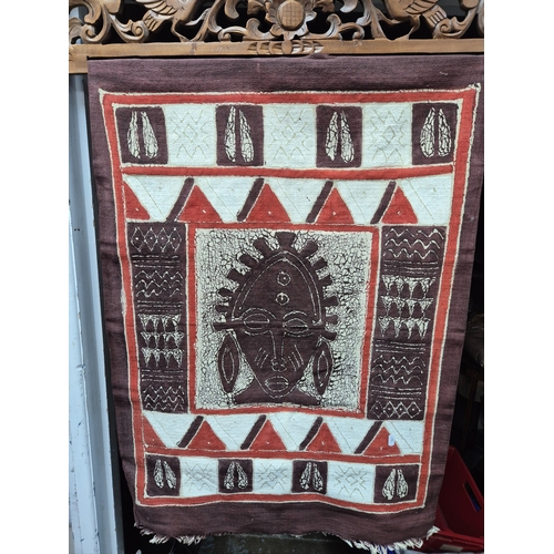 A Hanging Display of African Batik Textile on a Wooden Hanger
