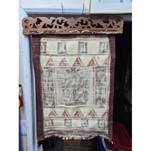 A Hanging Display of African Batik Textile on a Wooden Hanger
