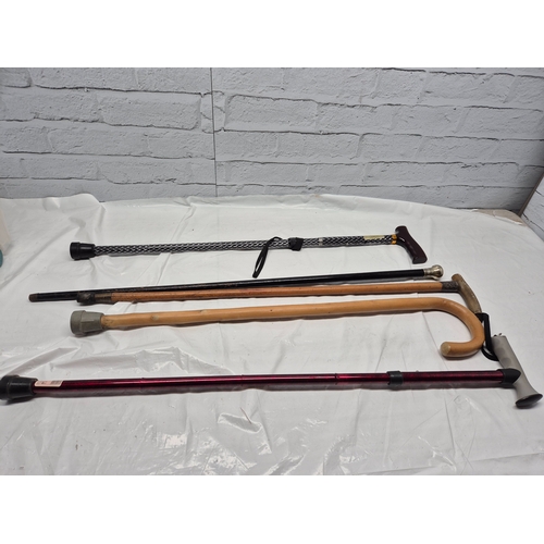 676A - A Collection of Walking Sticks to include Silver Handled example