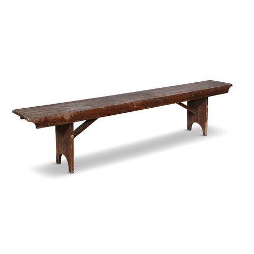 152 - A 19TH CENTURY STAINED LONG BENCH,  with plain seat above a shaped frieze with trestle feet and plai... 