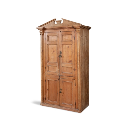 161 - A 19TH CENTURY STRIPPED PINE CUPBOARD WITH ARCHITECTURAL PEDIMENT,  above twin fielded panel doors e... 