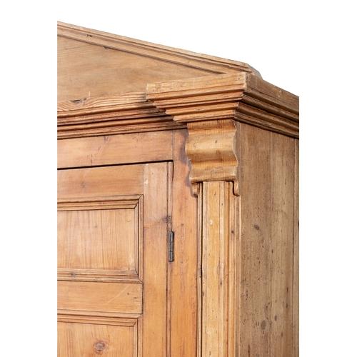 161 - A 19TH CENTURY STRIPPED PINE CUPBOARD WITH ARCHITECTURAL PEDIMENT,  above twin fielded panel doors e... 