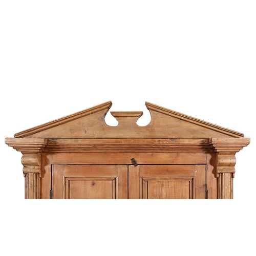 161 - A 19TH CENTURY STRIPPED PINE CUPBOARD WITH ARCHITECTURAL PEDIMENT,  above twin fielded panel doors e... 