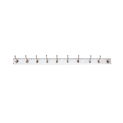 238 - AN EARLY 19TH CENTURY LONG WHITE PAINTED PINE COAT RACK,  with ten hooks mounted on a rectangular sh... 