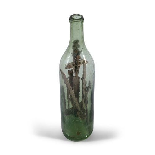 251 - AN UNUSUAL IRISH FOLK ART 'GOD IN A BOTTLE'  the green tinged glass bottle with crucifix mounted int... 