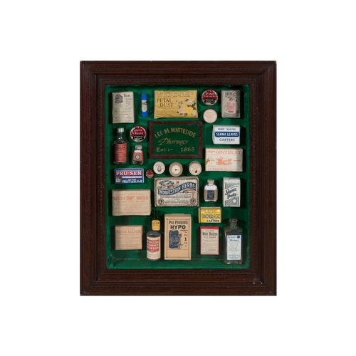 261 - A COLLECTION OF VICTORIAN CHEMIST SHOP PRODUCTS,   in a stained wood wall display case, 67cm, 56.7cm... 