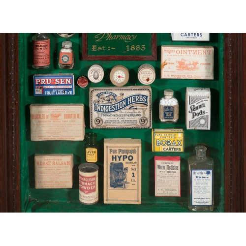 261 - A COLLECTION OF VICTORIAN CHEMIST SHOP PRODUCTS,   in a stained wood wall display case, 67cm, 56.7cm... 