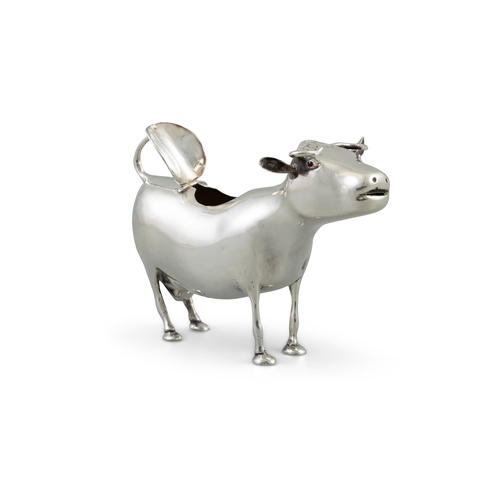 37 - A WHITE METAL COW CREAMER   makers mark 'MG', other marks rubbed, modelled standing, with hinged ope... 