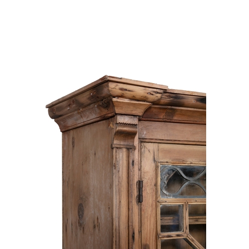 49 - A PINE BUREAU BOOKCASE,  the plain frieze top above twin glazed cupboard doors each with inset led a... 