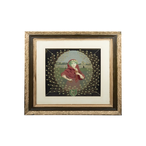 67 - A FRAMED EMBROIDERED PANEL  depicting a young woman with shawl surrounded by shamrocks above a crest... 