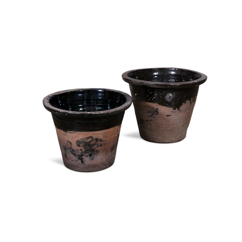 69 - TWO TERRACOTTA MILK CROCKS,  the moulded rim with glazed interior and body. 28cm and 30cm high respe... 