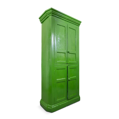 83 - A 19TH CENTURY GREEN PAINTED CUBOARD  the dentil cornice over twin four panel enclosing fitted inter... 