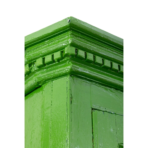 83 - A 19TH CENTURY GREEN PAINTED CUBOARD  the dentil cornice over twin four panel enclosing fitted inter... 