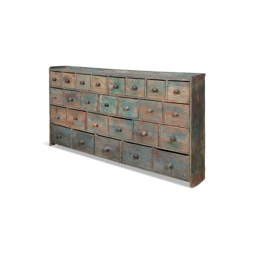 92 - A VARIEGATED BLUE PAINTED PINE GERNERAL MERCHANT'S BANK OF TWENTY-SIX DRAWERS,  the low gallery top ... 