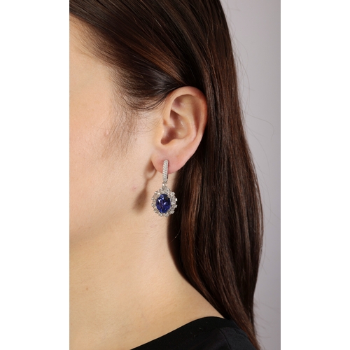 121 - A PAIR OF TANZANITE AND DIAMOND PENDENT EARRINGS  Each oval-shaped tanzanite weighing approximately ... 